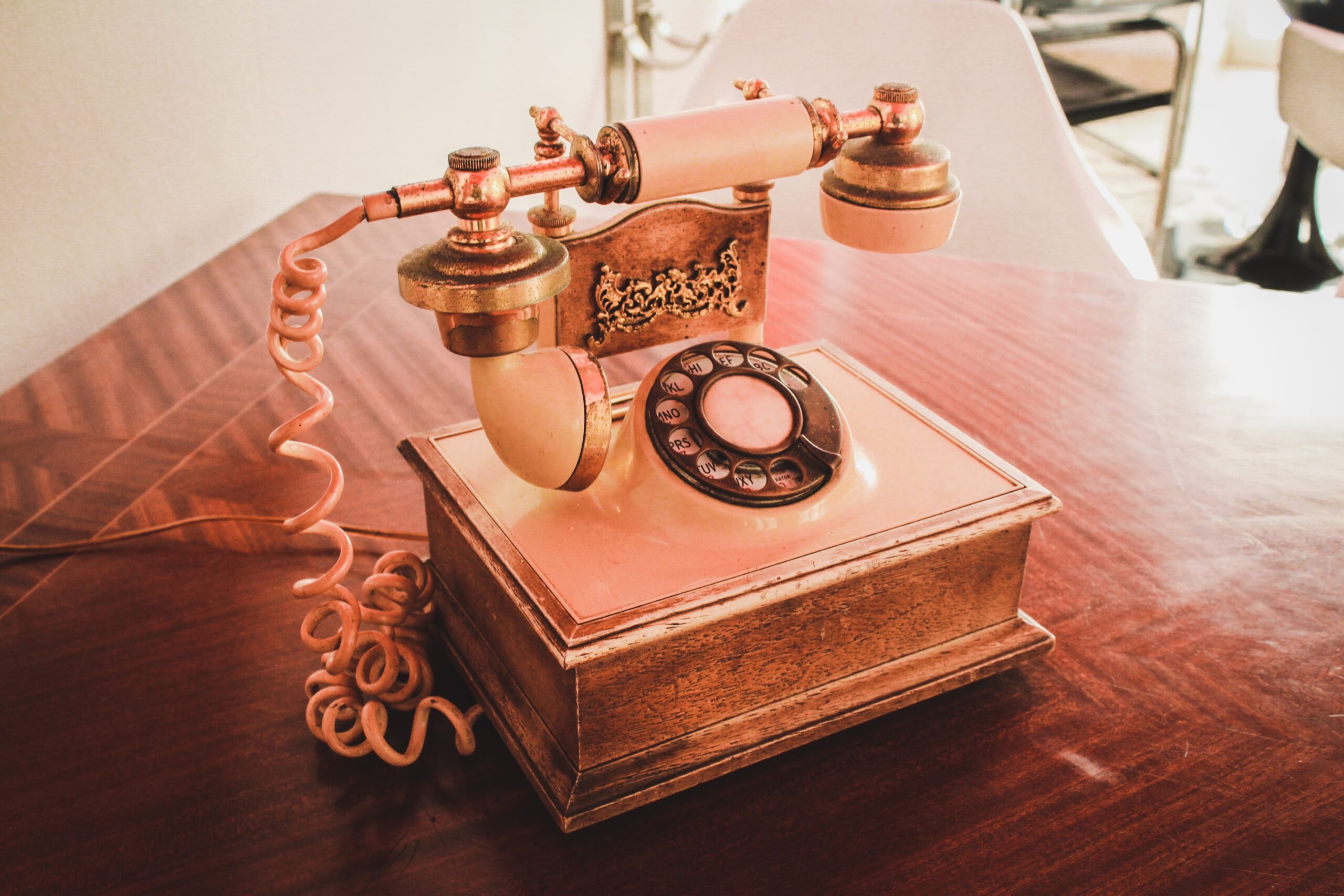 vintage pink rotary phone on a wooden table